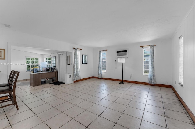 unfurnished living room with a wall mounted AC, plenty of natural light, and light tile patterned floors