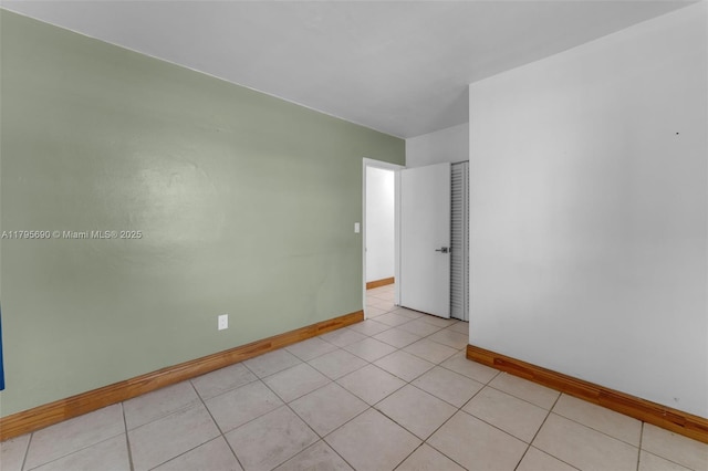 unfurnished room with baseboards and light tile patterned flooring