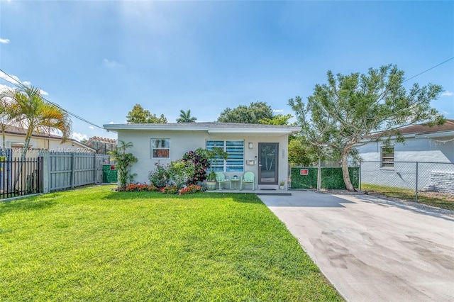 view of front of house with fence, stucco siding, concrete driveway, and a front yard