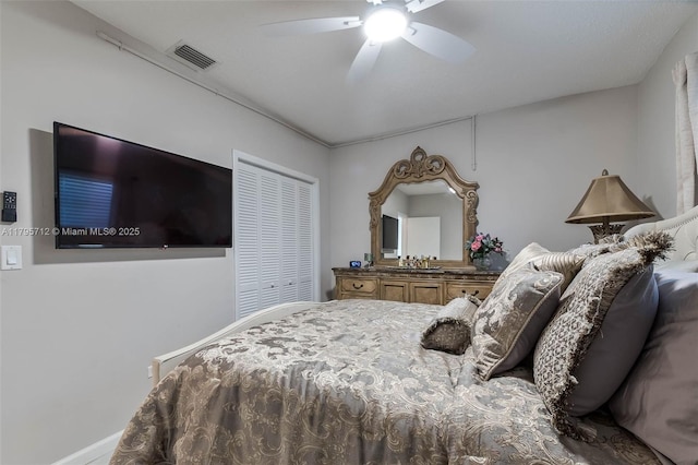 bedroom with baseboards, ceiling fan, a closet, and visible vents
