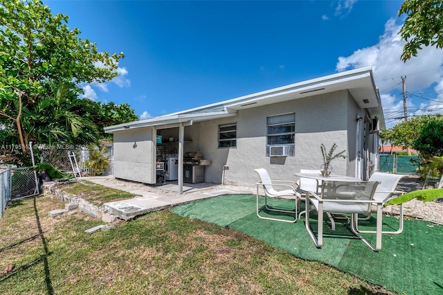 back of property featuring a patio area, stucco siding, a yard, and fence