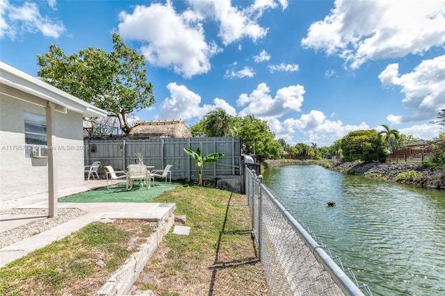 view of yard with a patio, a water view, and a fenced backyard