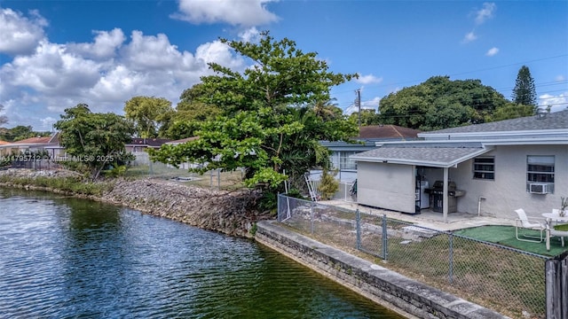 dock area featuring a patio, a fenced backyard, and a water view
