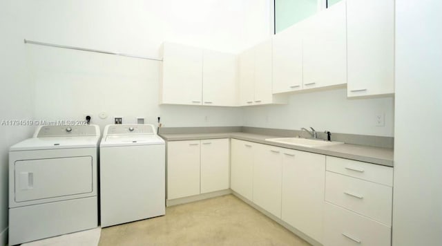 laundry room with cabinet space, washing machine and dryer, and a sink