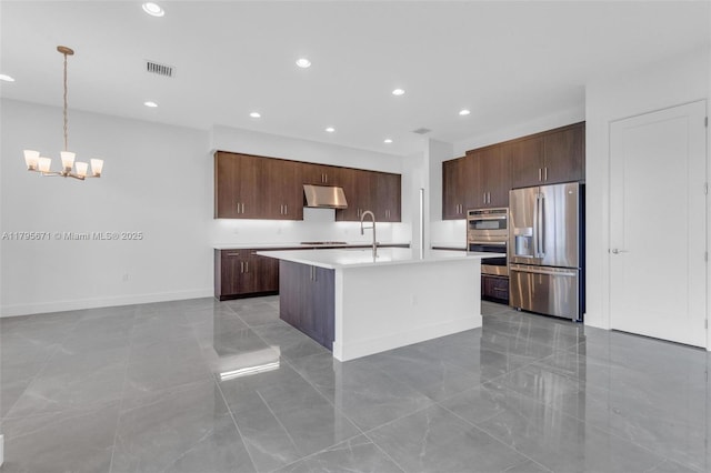 8215 Crystal Downs Ave, Boca Raton, FL 33434 - kitchen featuring appliances with stainless steel finishes, under cabinet range hood, light countertops, a center island with sink, and a chandelier
