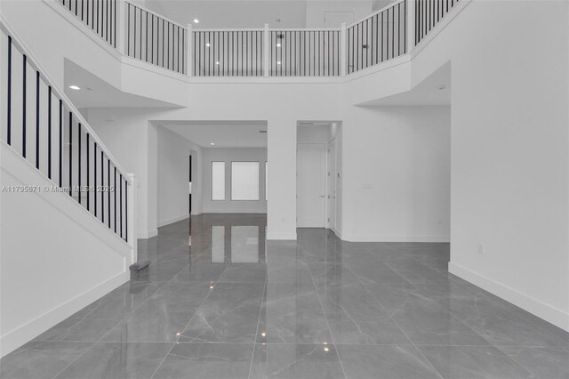 8215 Crystal Downs Ave, Boca Raton, FL 33434 - unfurnished living room with marble tiled flooring, baseboards, a high ceiling, and stairway