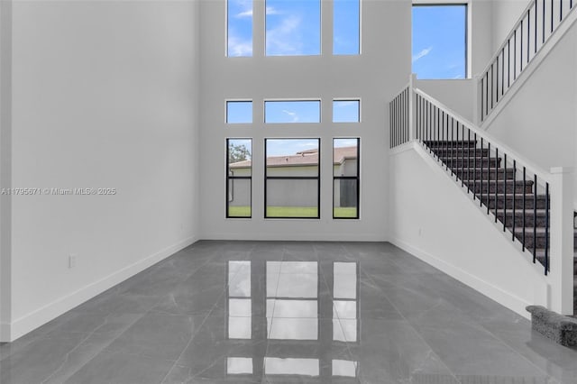 8215 Crystal Downs Ave, Boca Raton, FL 33434 - unfurnished living room featuring a high ceiling, stairway, and baseboards
