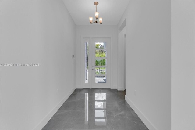 8215 Crystal Downs Ave, Boca Raton, FL 33434 - doorway with baseboards, a chandelier, and marble finish floors