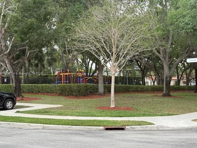 view of home's community with a lawn and playground community
