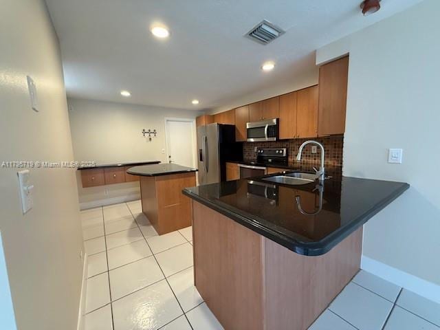 kitchen featuring visible vents, a sink, a peninsula, and stainless steel appliances