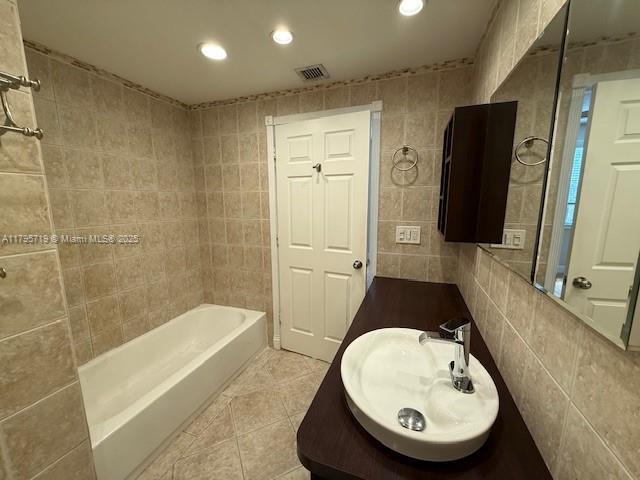 bathroom with visible vents, tile walls, vanity, tile patterned floors, and recessed lighting