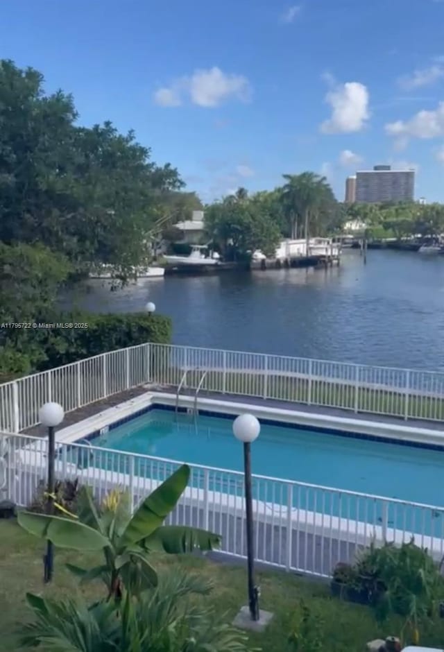 view of pool with a water view, fence, and a fenced in pool