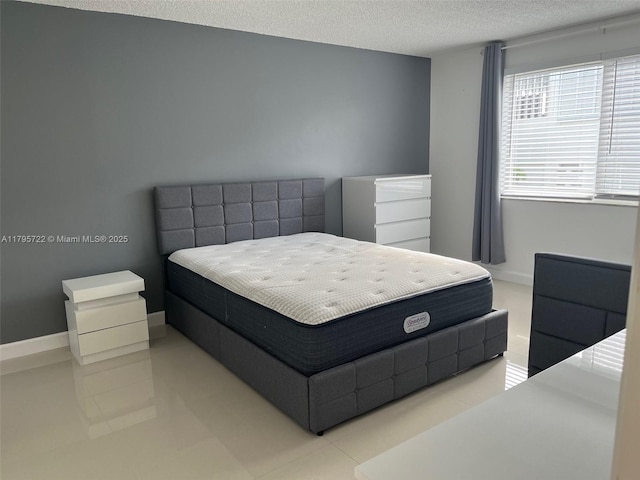 bedroom featuring a textured ceiling and light tile patterned floors