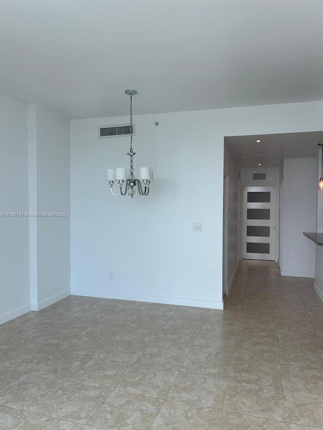 unfurnished dining area featuring baseboards, visible vents, and an inviting chandelier