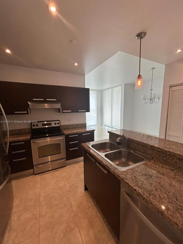 kitchen with under cabinet range hood, a sink, appliances with stainless steel finishes, light tile patterned floors, and decorative light fixtures