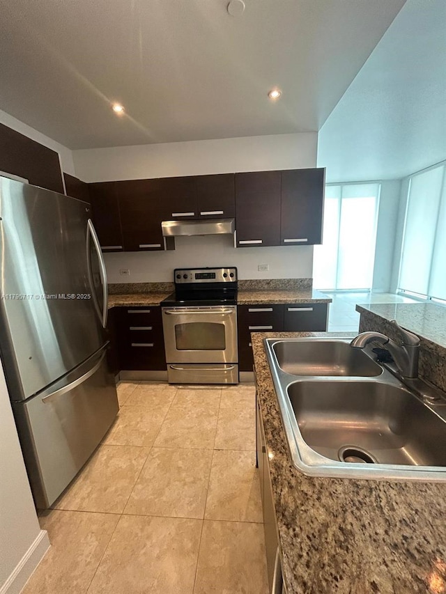 kitchen featuring light tile patterned flooring, a sink, stainless steel appliances, under cabinet range hood, and modern cabinets