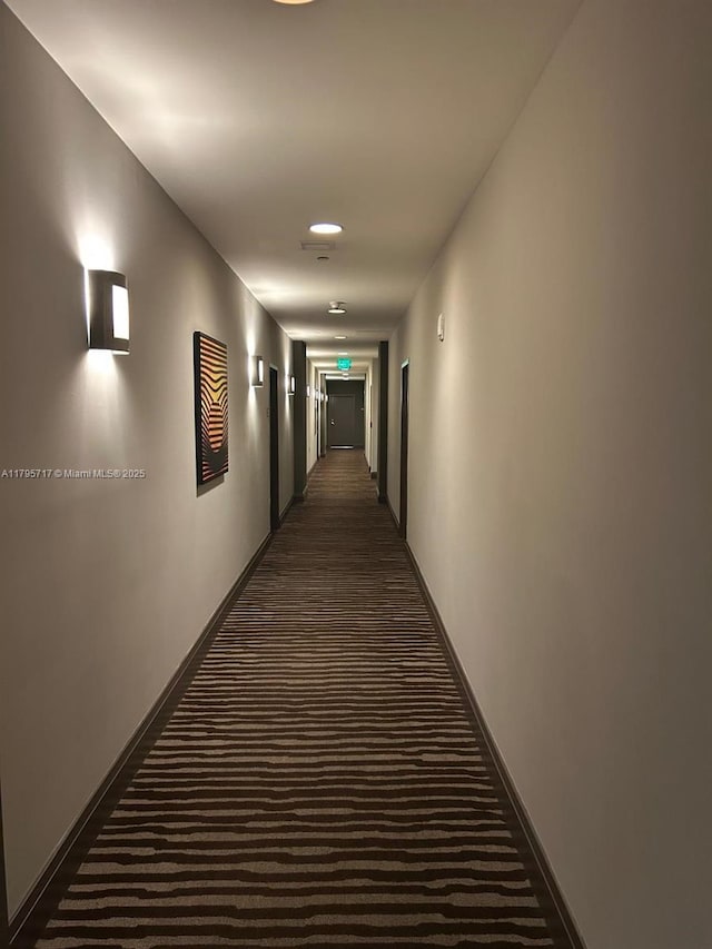 corridor with carpet flooring and baseboards
