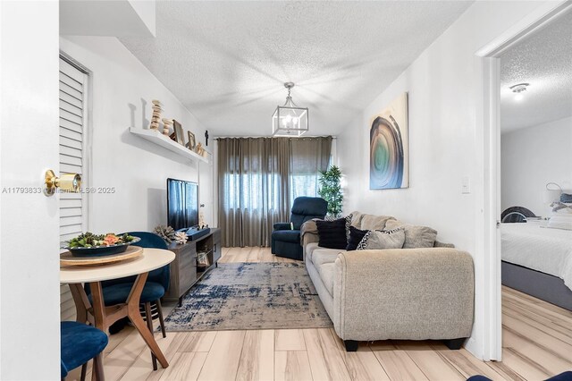 839 W 39th Pl, Hialeah, FL 33012 - living room featuring a textured ceiling, a chandelier, and wood finished floors