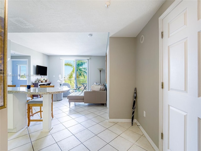 living area featuring baseboards and light tile patterned flooring