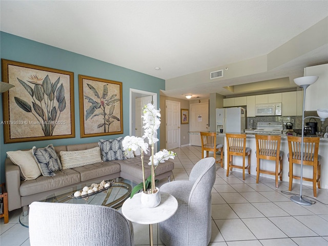 living area with light tile patterned floors and visible vents