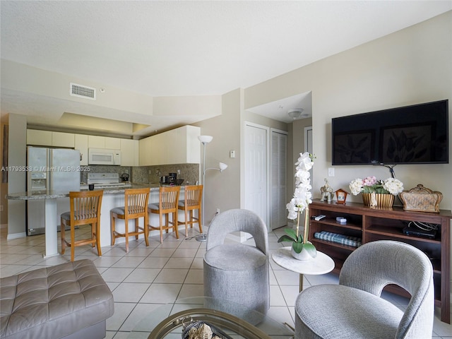 living room with light tile patterned flooring and visible vents