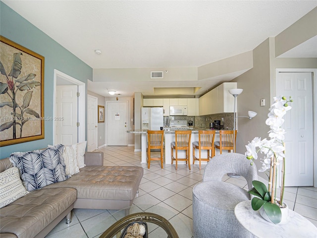 living room featuring light tile patterned flooring, baseboards, and visible vents