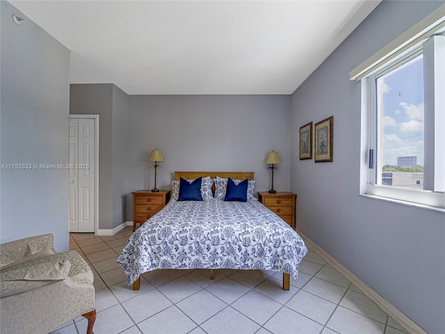 bedroom with a closet, baseboards, and light tile patterned flooring