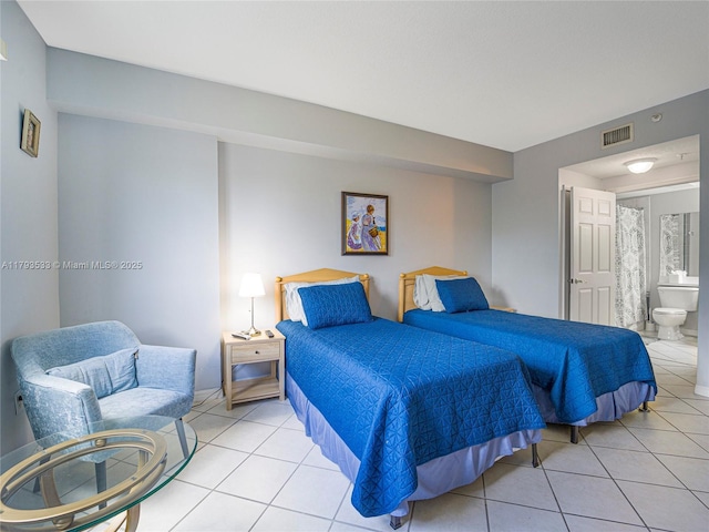 bedroom with light tile patterned floors, connected bathroom, and visible vents