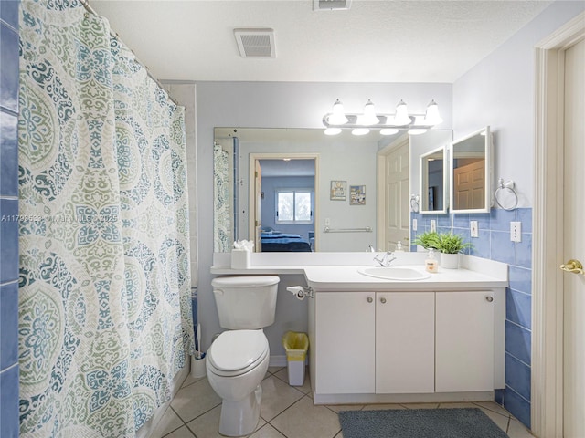 bathroom with toilet, tile patterned floors, visible vents, and vanity