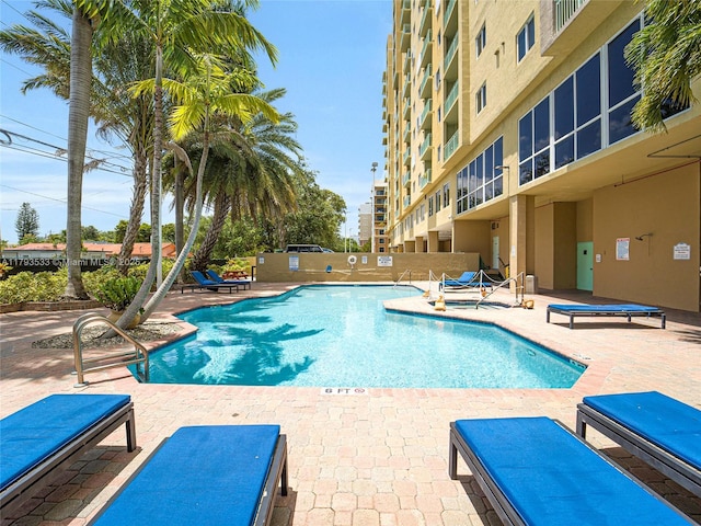 community pool featuring fence and a patio