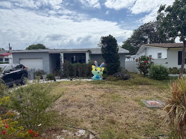 ranch-style home with an attached garage, fence, and a front yard