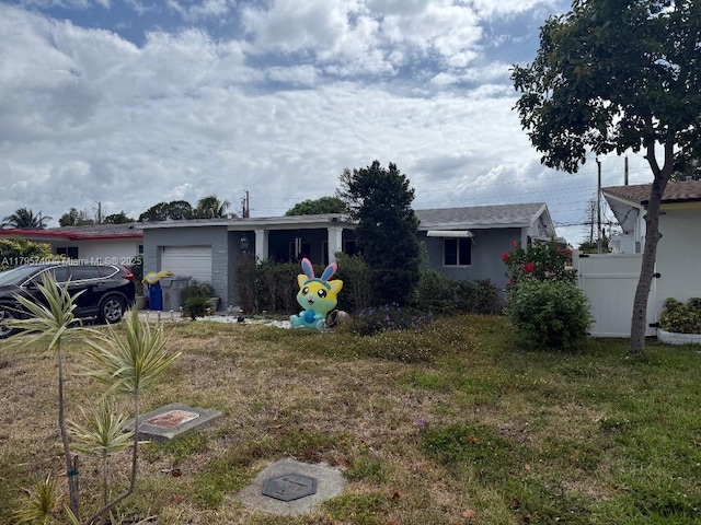 ranch-style house featuring a garage and a front lawn