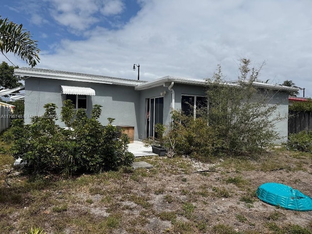 back of property featuring stucco siding