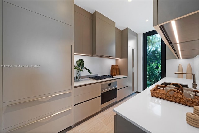 5515 Pine Tree Dr, Miami Beach, FL 33140 - kitchen featuring oven, gray cabinets, modern cabinets, gas stovetop, and light countertops