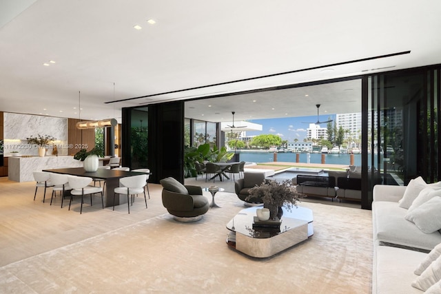 5515 Pine Tree Dr, Miami Beach, FL 33140 - living area with floor to ceiling windows, a water view, and a chandelier