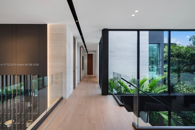 5515 Pine Tree Dr, Miami Beach, FL 33140 - hallway with floor to ceiling windows and wood finished floors