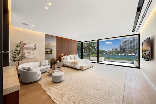 5515 Pine Tree Dr, Miami Beach, FL 33140 - bedroom with light wood-type flooring, a wall of windows, access to outside, and recessed lighting