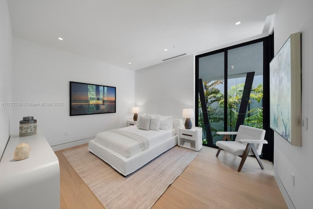 5515 Pine Tree Dr, Miami Beach, FL 33140 - bedroom with light wood-style flooring, floor to ceiling windows, recessed lighting, and baseboards