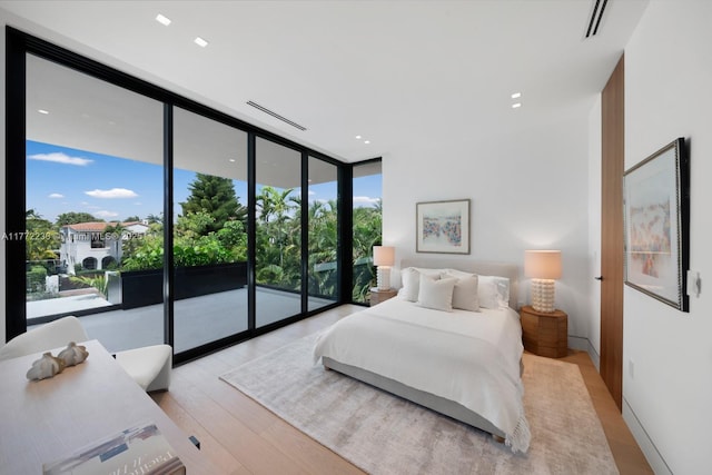 5515 Pine Tree Dr, Miami Beach, FL 33140 - bedroom with floor to ceiling windows, access to outside, and light wood finished floors