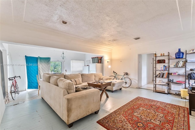 living area with visible vents, a textured ceiling, and wood finished floors