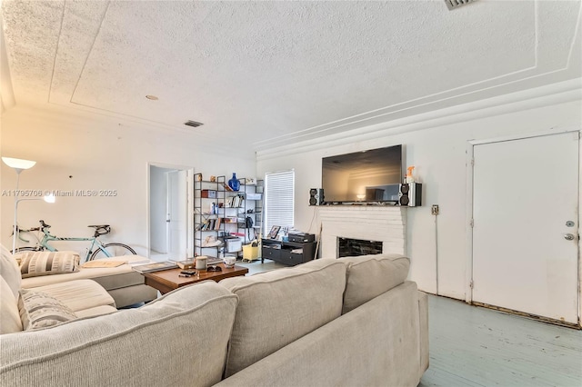 living area with a textured ceiling and a fireplace