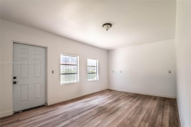 empty room with baseboards and wood finished floors