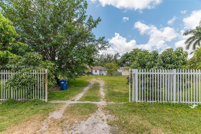 view of gate featuring a lawn and fence