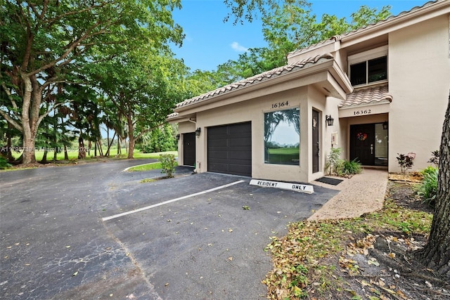 exterior space with stucco siding and a tile roof