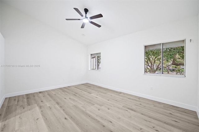 empty room featuring baseboards, ceiling fan, vaulted ceiling, and wood finished floors