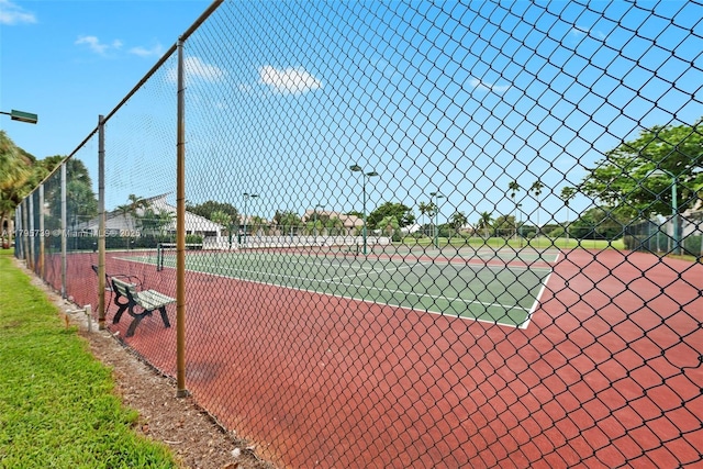 view of tennis court featuring fence