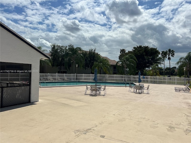 pool featuring fence and a patio area