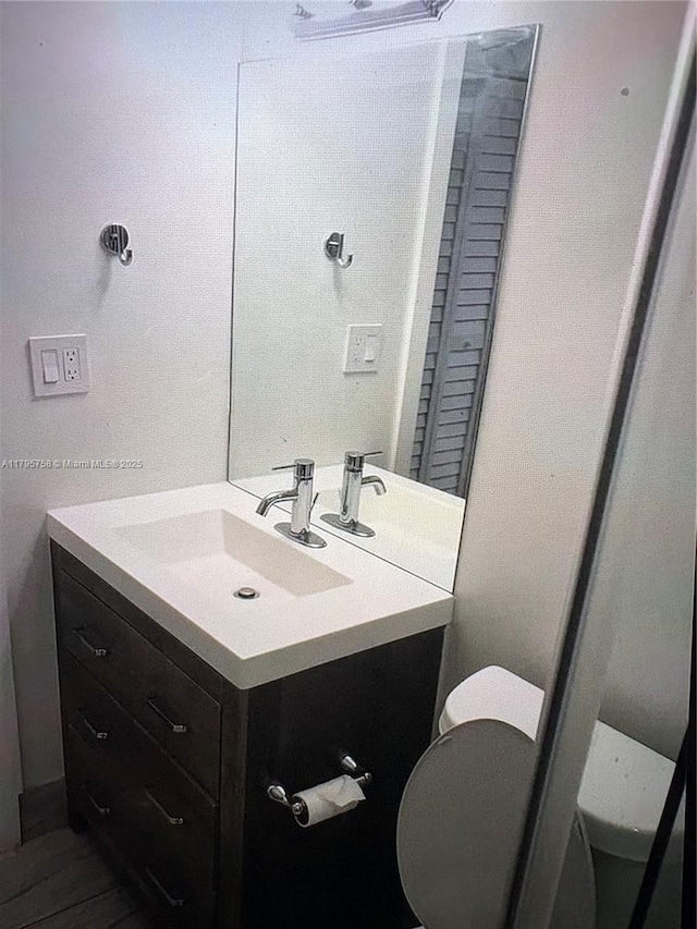 bathroom featuring vanity and toilet