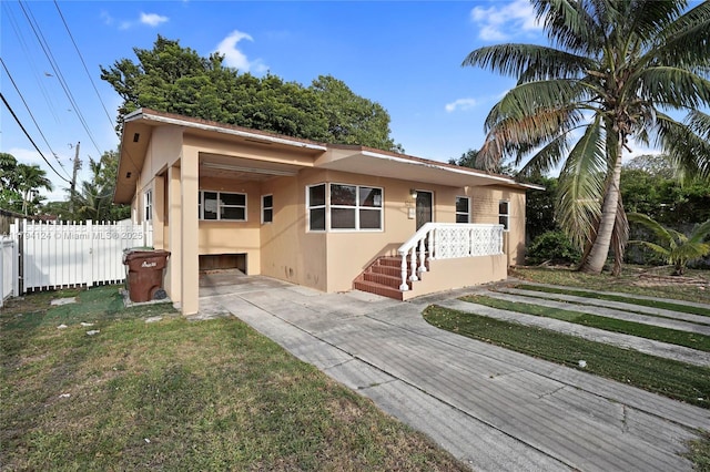 4241 W 1st Ave, Hialeah, FL 33012 - view of front of home with fence, stucco siding, and concrete driveway