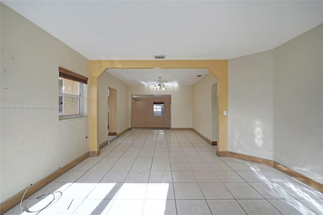 4241 W 1st Ave, Hialeah, FL 33012 - entrance foyer with visible vents, arched walkways, baseboards, a notable chandelier, and light tile patterned flooring